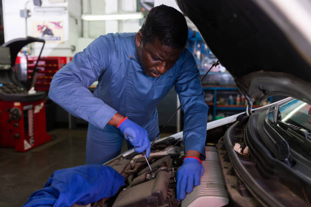 istock Professional american mechanic man in uniform repairing car engine 1321175298