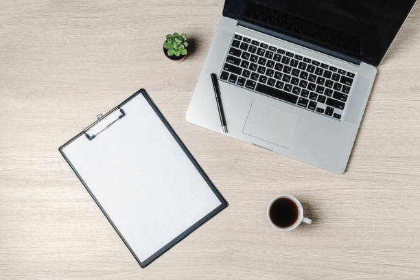 istock Office table with notepad, computer and coffee cup. Mockup, top view with copy space. Office desk table concept. 1321177440