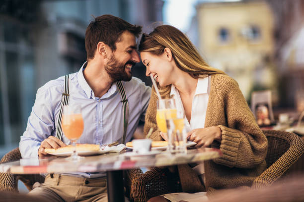 istock Young couple sitting in a restaurant eating pizza 1321177868