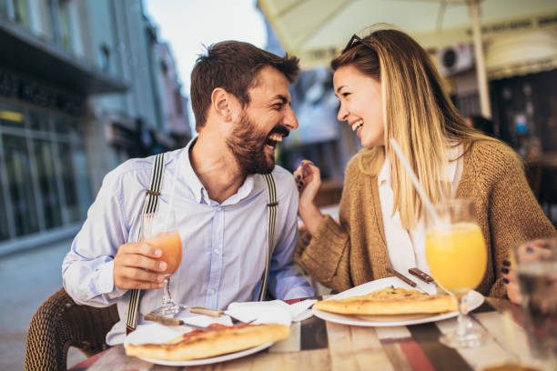 istock Young couple sitting in a restaurant eating pizza 1321178742