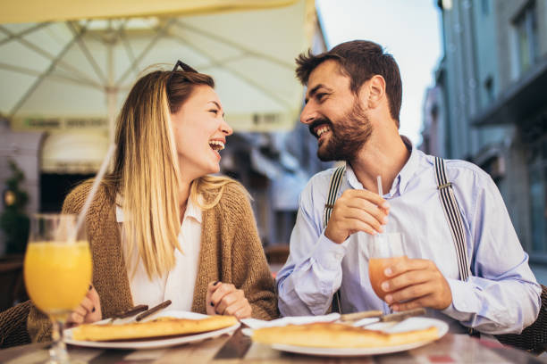istock Young couple sitting in a restaurant eating pizza 1321178892