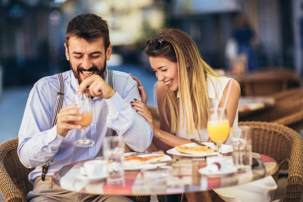 istock Young couple sitting in a restaurant eating pizza 1321180268
