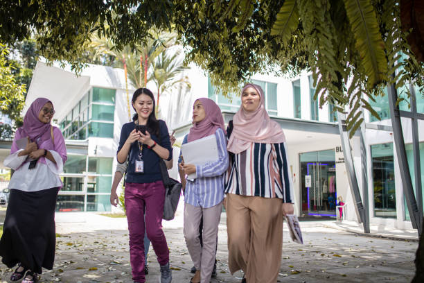 istock Group of Asian university student walking out from education building talking 1321180480
