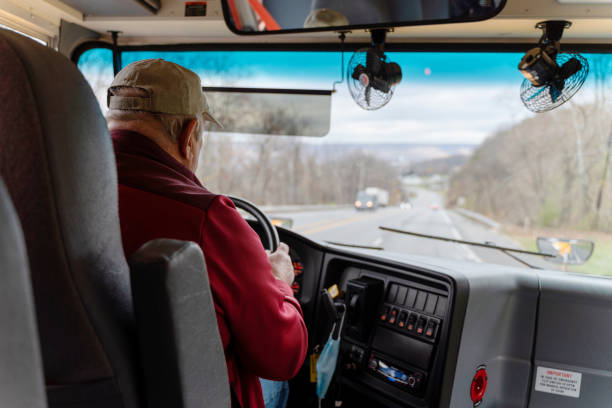 istock Senior man, the bus driver, driving a school bus. 1321183999