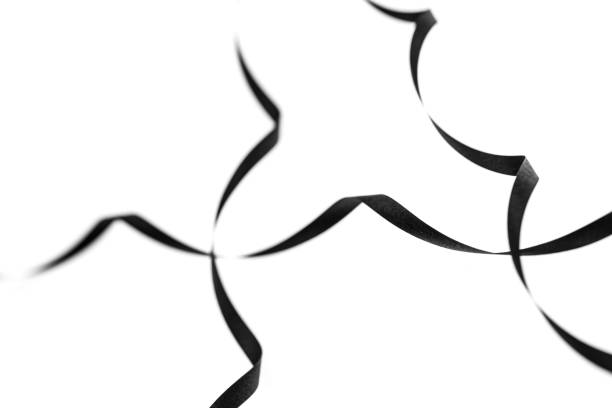 A curled black paper ribbons. Abstract artistic patterns. Design concept. Ready solutions for interior design office. Macro lens close up shot 1:1. Monochrome image.