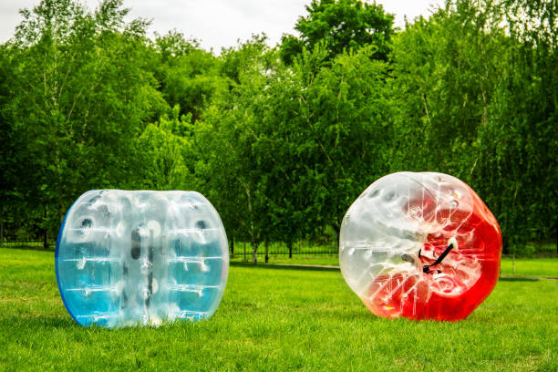 Two Zorbing Balloon on the summer lawn. inflatable zorb ball outdoor. Leisure activity concept with copy space Two Zorbing Balloon on the summer lawn. inflatable zorb ball outdoor. Leisure activity concept with copy space. zorbing stock pictures, royalty-free photos & images
