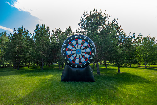 Large inflatable target outdoor. Giant darts in the yard. Summer leisure activity concept, copy space.
