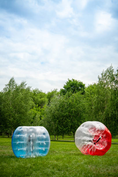 2 Zorbing Balloon on the summer lawn. inflatable zorb ball outdoor. Leisure activity concept with vertical copy space 2 Zorbing Balloon on the summer lawn. inflatable zorb ball outdoor. Leisure activity concept with vertical copy space. zorbing stock pictures, royalty-free photos & images