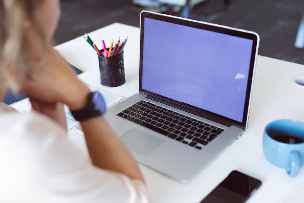 African american woman using laptop with copy space on screen. independent creative business at a modern office.