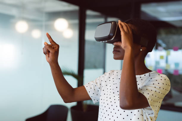 istock Smiling african american woman using vr headset at work 1321187423