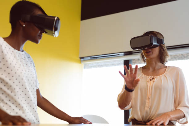 istock Diverse businesswomen standing at desk using vr headset at work 1321188814