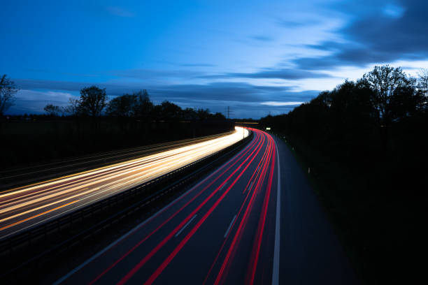 istock Light trails on the Autobahn with nice blue sky 1321189677