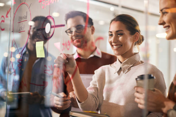istock Team of happy entrepreneurs making plans on a glass wall while working in the office. 1321190466