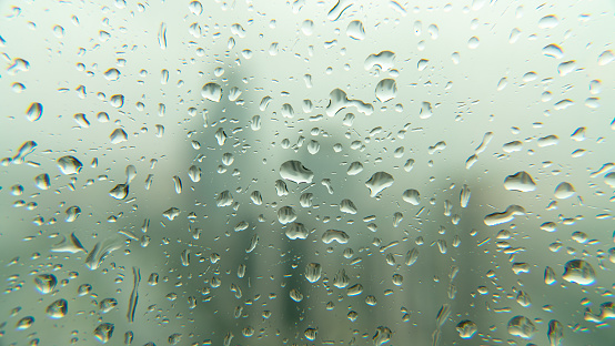 Drops of rain on window glass with blurred skyscraper financial district Istanbul city skyline, Turkey. Autumn Abstract Backdrop
