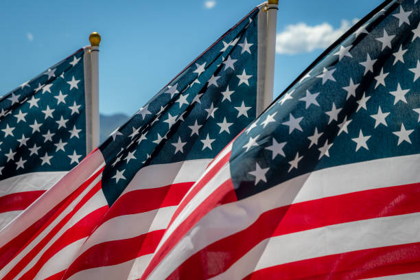 istock Close Up of Three American Flags Blowing in the Wind 1321194093
