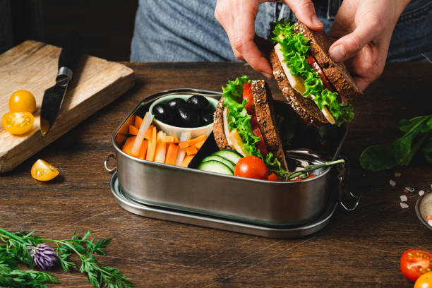 nahaufnahme einer frau, die eine gesunde lunchbox zubereitet - bento box lunch healthy lifestyle stock-fotos und bilder