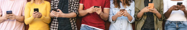 istock Group young friends using mobile smartphone outdoor - Millennial generation people having fun with new trends social media apps - Youth addiction to technology concept 1321196065