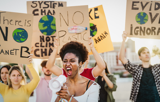 Demonstrators group protesting against plastic pollution and climate change - Multiracial people fighting on road holding banners on environments disasters - Global warming concept