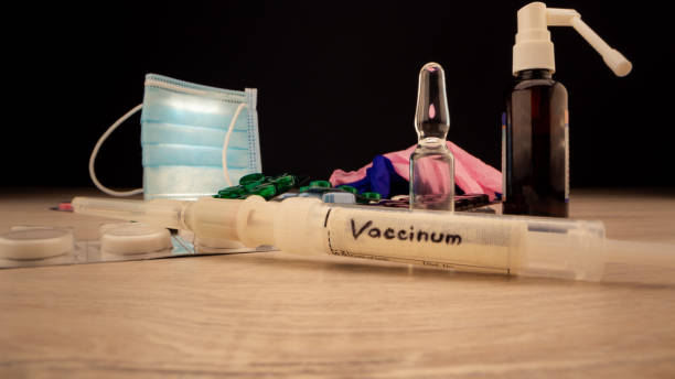 istock Small syringe with covid-19 vaccine over yellow pills 1321199529