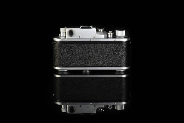 istock Rare old rangefinder camera, released 50's on black glass background. 1321200083