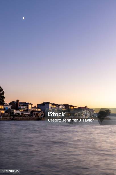 Sunset Over Coastline With Houses And Moon In Sky Stock Photo - Download Image Now - Tacoma, Washington State, Lake