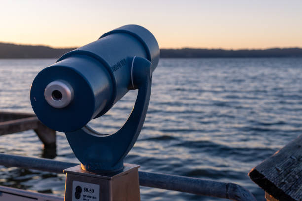 istock Telescope Viewer Pointing Towards Sunset Over Water 1321200855