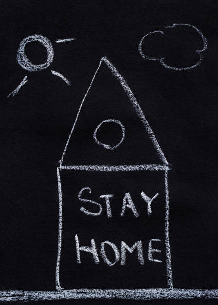 istock Drawing with chalk on a black blackboard, house with text Stay Home 1321200991