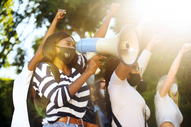 istock Diverse young female friends shouting slogans during a women's rights march 1321201104