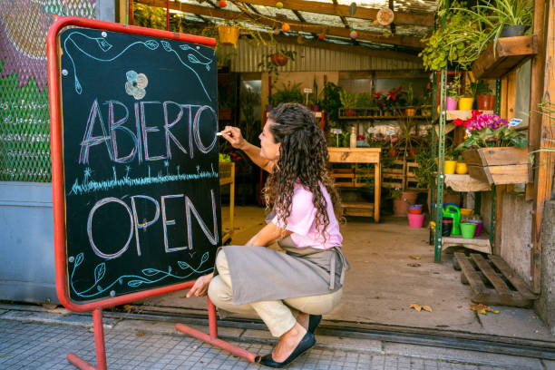 istock Shop owner drawing open on blackboard sign 1321203500