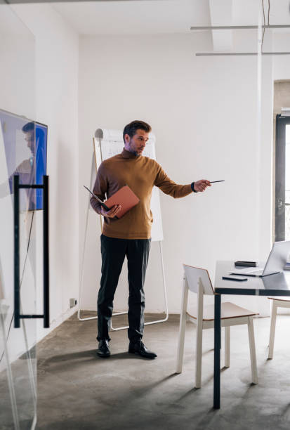 istock Handsome Young Businessman Giving a Presentation on his Project at Work 1321204853