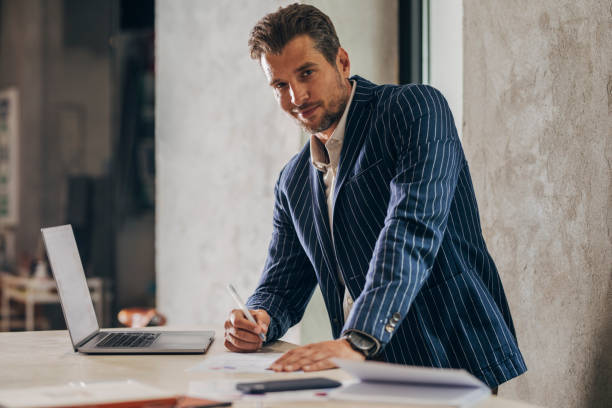 istock Businessman in a Suit Working at a Standing Desk 1321204880