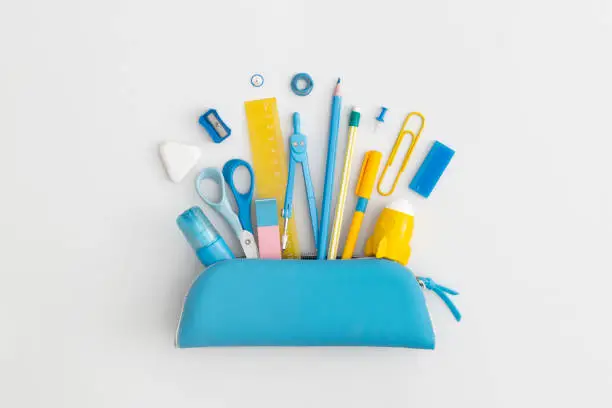 Photo of Pencil case with school stationery on a grey background. Top view. Flat lay. Back to school concept.