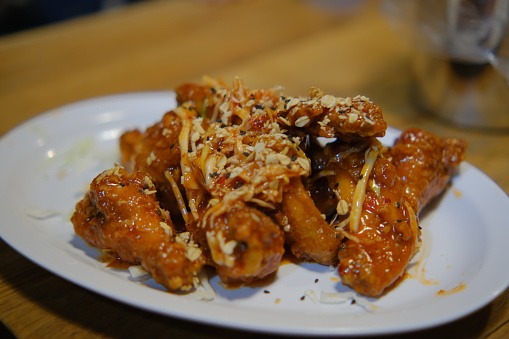 Crispy Thai chili Asian flavor chicken wings in white plate on table