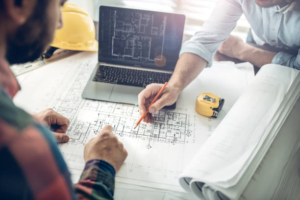 Teamworking is the key for success Hands of an architect and a building contractor pointing at the architectural plan on the screen. They have a coordination meeting to solve the site problems computer aided design stock pictures, royalty-free photos & images