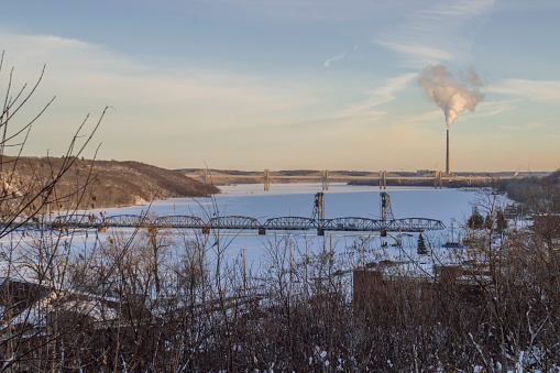 A Medium Landscape Shot of Rural Midwestern American Bridges over the St. Croix River Covered in Snow During a Winter Sunset