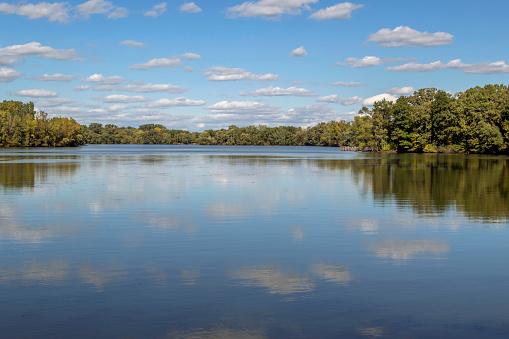 A Wide Angle Landscape Shot of Clouds Reflecting in Colby Lake as Summer begins to change into Fall in Suburban St Paul