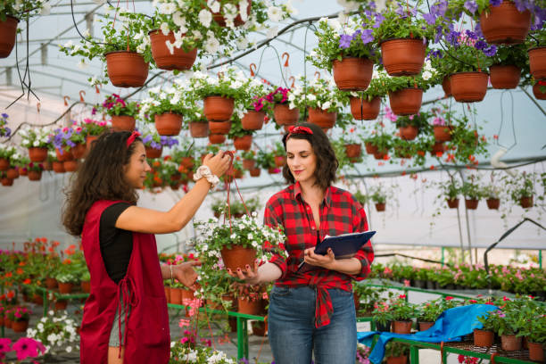 istock Two attractive young women working in greenhouse 1321211663