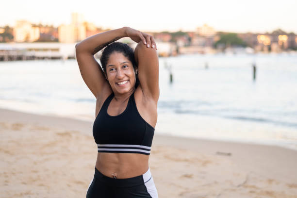 istock Stunning ethnic woman stretches triceps on beach 1321220598