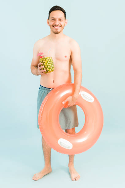 istock Happy man enjoying a pina colada on the beach 1321222548