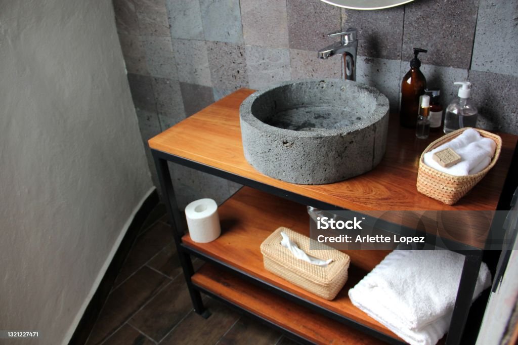 Bathroom in interior with gray stone wall and sink with white towels Bathroom  with gray stone wall and sink Apartment Stock Photo