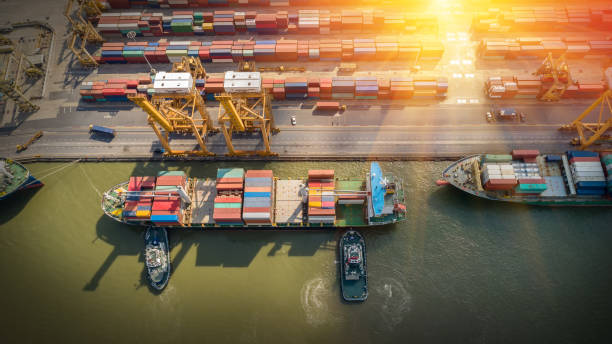 istock Logistics and transportation of Container Cargo ship and Cargo plane with working crane bridge in shipyard at sunrise, logistic import export and transport industry background 1321236261