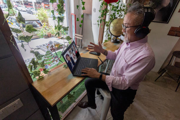 homem asiático tem reunião de negócios via chamada de vídeo em um café - chinese pattern audio - fotografias e filmes do acervo