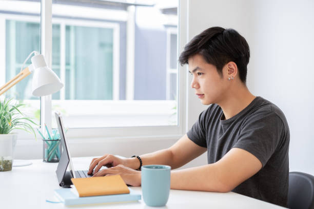 istock Asian male business in casual wear working from home using tablet computer. 1321240824