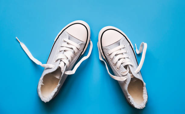 istock blue sneakers with white laces on a blue background. 1321241808