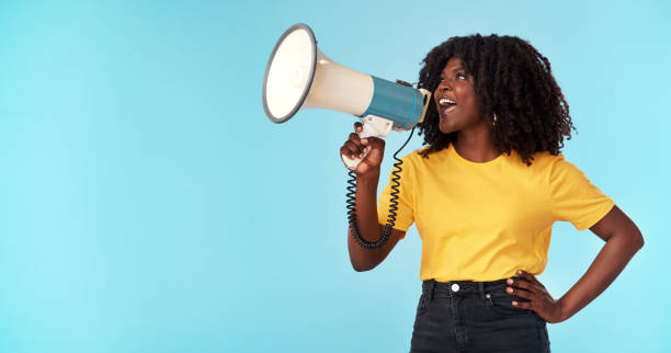 istock Studio shot of an attractive young woman using a megaphone against a blue background 1321242525