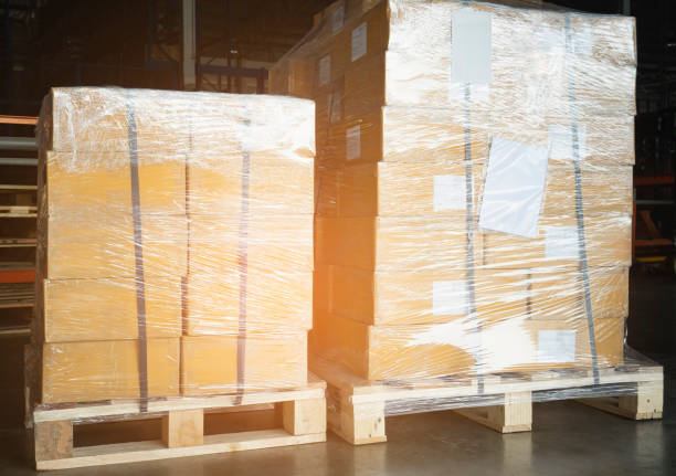 istock Stacked of Package Boxes Wrapped Plastic Film on Pallet at Storage Warehouse. Shipment Boxes. Cargo Export- Import. 1321242594