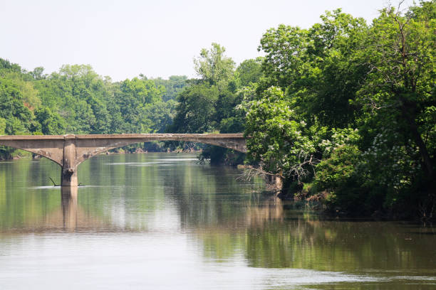 istock old abandoned concrete arch roadway or train railway bridge over a calm river with trees and clear sky 1321247851