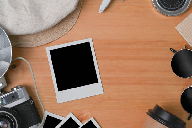 istock Blank photo frame, camera, cup and sunglasses on wooden background. 1321248936