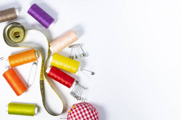 istock Sewing supplies, thread pins needles on white as a frame, flat layer, place for text, copy space. 1321249968