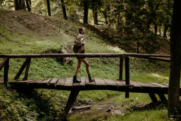 istock Female crossing nature bridge 1321250024